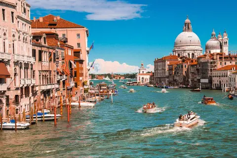 Venedig, ein Traumziel für jeden Kurztrip in Europa. Boote gleiten über das türkisfarbene Wasser, vorbei an prächtigen Palästen und der imposanten Basilika Santa Maria della Salute.