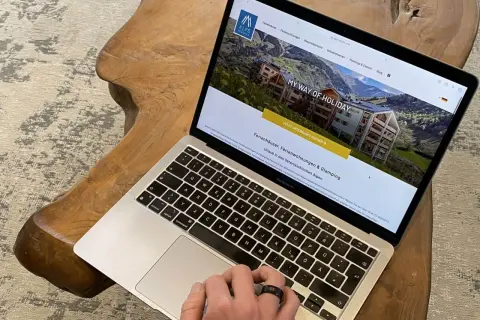 Laptop zeigt Webseite für Ferienhäuser in den Alpen. Perfekt für die einkaufsliste urlaub selbstversorger.
