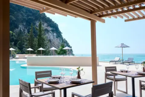 Ein gedeckter Tisch am Pool mit Blick aufs Meer. Der alkyna lifestyle beach resort bietet pure Entspannung.