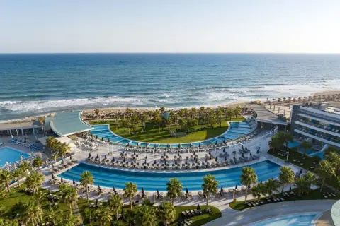 Traumhafter Blick auf das Lyttos Mare auf Kreta: Palmen, Pools und das azurblaue Meer.