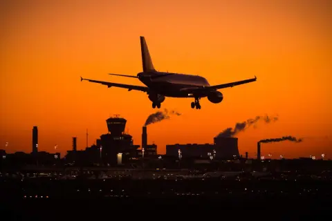 Flugzeug landet bei Sonnenuntergang in Deutschland. Tipps gegen Jetlag USA nach Deutschland: Anpassung der Schlafenszeiten.
