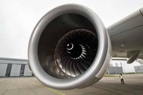 Detailaufnahme eines riesigen Triebwerks der A380. Im Hintergrund die Airbus-Halle und eine Person in Warnweste.