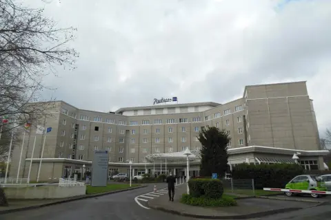 Das Radisson Blu Hotel Dortmund, ein imposantes Gebäude mit vielen Fenstern, empfängt seine Gäste unter einem grauen Himmel.