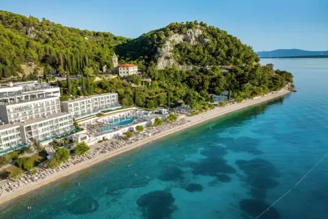 Traumhafter TUI Blue Adriatic Beach mit kristallklarem Wasser, weißen Hotels und grünen Hügeln. Ein Paradies zum Entspannen.