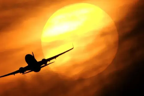 Flugzeug im Gegenlicht der Sonne, das zeigt, dass sich Meilen sammeln für solche Erlebnisse lohnt.