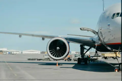 Großes Flugzeug mit geöffneter Ladeluke und Triebwerk auf dem Rollfeld. Bald geht es los, um mit dem Flugzeug fliegen zu können.