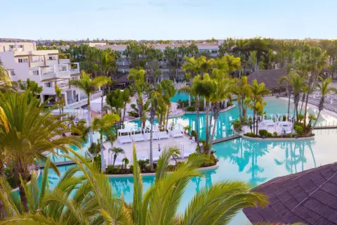 Traumhafter Poolbereich im TUI Kids Club Maspalomas Princess mit Palmen und Liegen.