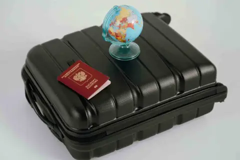 Reisekoffer mit Reisepass und Globus. Wo kann man Geld wechseln? Am Flughafen oder in der Bank.