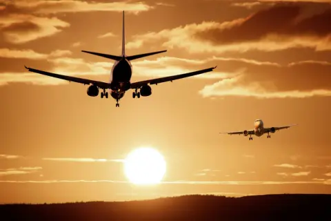 Zwei Flugzeuge im Sonnenuntergang, bereit für den Start. Ein Gefühl von Freiheit, wie ein blind ticket in den Himmel.
