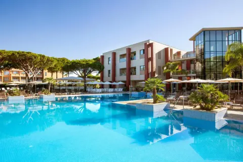 Einladender Poolbereich mit Palmen und Liegestühlen. Das Hotel mit moderner Architektur und dem TUI Kids Club Barrosa Garden verspricht einen tollen Urlaub.