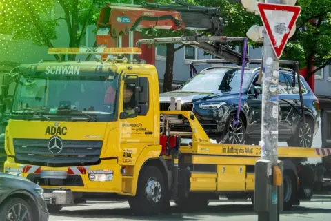 Gelber ADAC Abschleppwagen mit dunklem SUV auf der Ladefläche in Berlin. Informiert über die Kosten für Abschleppen in Berlin.