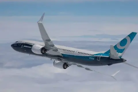 Boeing 737 MAX im Flug, ein Beispiel für sicherste Flugzeuge, mit blau-weißer Bemalung und dem Logo auf dem Heck.