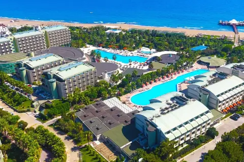 Luftaufnahme des von Resort Golden Coast, mit mehreren Gebäuden, Pools und dem Meer im Hintergrund.