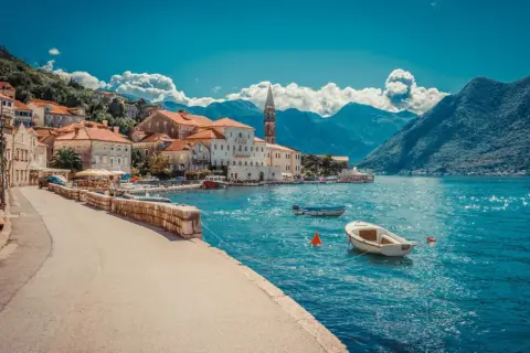 Traumhafte Küstenstadt mit roten Dächern und Booten im türkisfarbenen Wasser. Ein perfektes Beispiel für Urlaubsziele in Europa.
