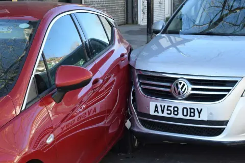 Mein parkendes Auto wurde angefahren. Ein rotes Auto ist seitlich gegen einen silbernen VW gestoßen.