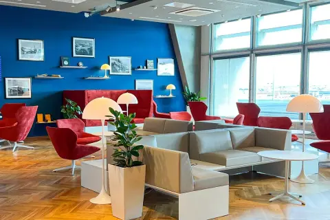 Gemütliche Lounge mit roten Sesseln und grauen Sofas, ideal für Reisende mit Priority Pass Stuttgart.