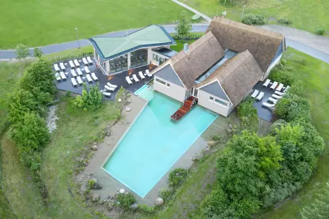 Beech Resort Plauer See: Einladender Poolbereich mit Liegen und moderner Architektur, umgeben von Grün.