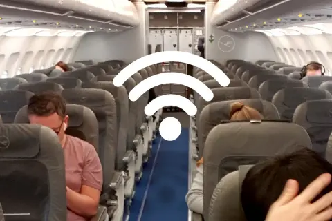 WLAN im Flugzeug: Passagiere sitzen in Reihen auf Flugzeugsitzen, während ein großes WLAN-Symbol über ihnen schwebt.