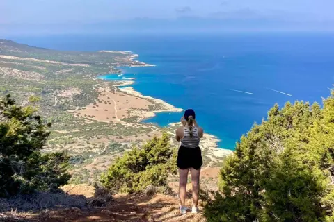 Frauenblick auf die Küste Zyperns. Ein perfekter Zypern Urlaub mit Blick aufs türkisfarbene Meer und die Insel.