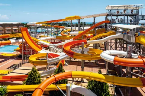 Bunte Wasserrutschen im aqi pegasos world Wasserpark, die sich durch die Luft schlängeln.