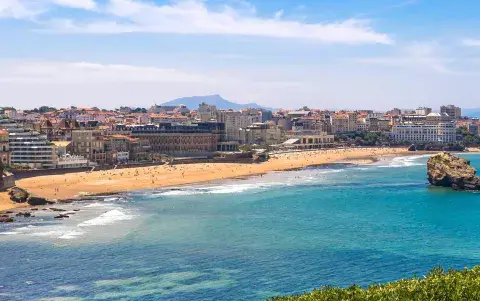 Traumhafter Frankreich Urlaub am Meer: Küstenstadt mit Sandstrand, Felsen und türkisfarbenem Wasser.