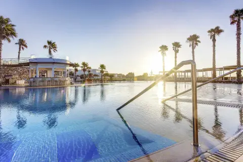 Ein traumhafter Poolbereich mit Palmen und einer Bar im TUI Magic Life Plimmiri.