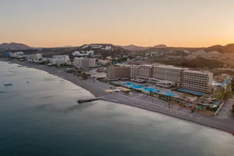 Amada Colossos Resort Rhodos: Weitläufige Hotelanlage mit Pools und Strand am Meer, umgeben von Hügeln.