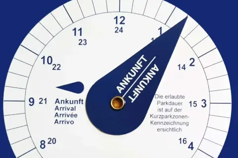 Eine Parkscheibe zeigt die Ankunftszeit. Man muss die Parkscheibe aufrunden, um die erlaubte Parkdauer einzuhalten.
