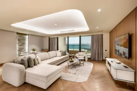 Luxuriöses Wohnzimmer mit Meerblick im Regnum The Crown Belek. Ein großes Ecksofa lädt zum Entspannen ein.