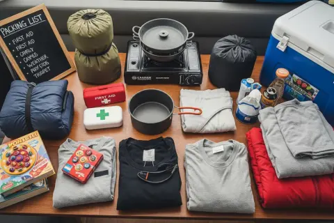 Checkliste Camping Wohnwagen: Schlafsäcke, Kocher, Kühltruhe, Kleidung, Erste-Hilfe-Kasten und Spiele für das Abenteuer.