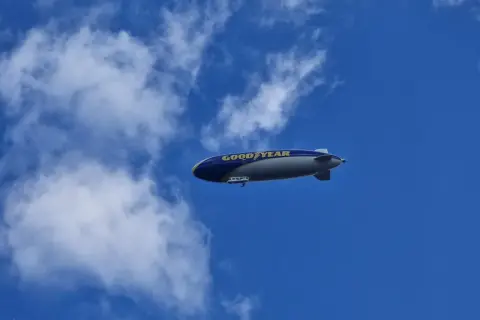 Ein Goodyear-Zeppelin schwebt am blauen Himmel. Wie viele Zeppeline es gibt, ist unklar, aber dieser hier ist gut sichtbar.