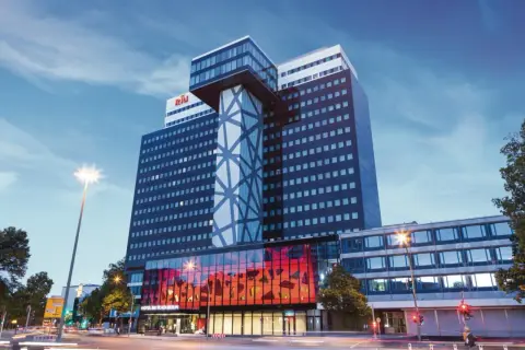 Das Hotel RIU Plaza Berlin ragt mit seiner modernen Architektur in den Abendhimmel.