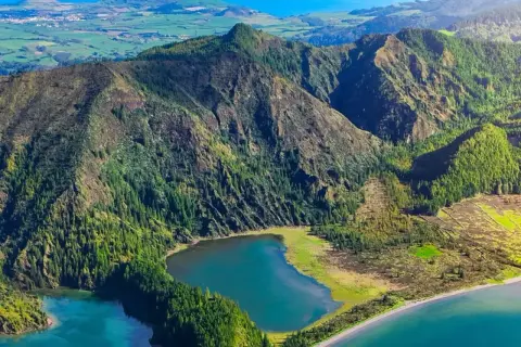 Grüne Berge und ein blauer See auf den Azoren. Ein perfekter Ort für einen unvergesslichen Azoren Urlaub.