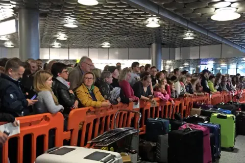 Menschen stehen Schlange bei einer Kofferversteigerung in Hannover. Viele Koffer warten auf neue Besitzer.
