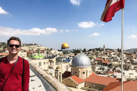 Glücklicher Mann genießt seinen Urlaub in Israel mit Blick auf die Altstadt von Jerusalem und den Felsendom.