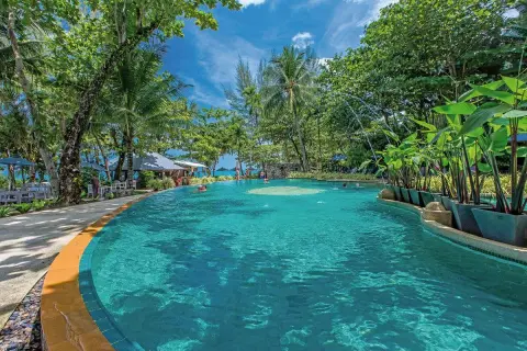 Einladender Poolbereich im Moracea by Khao Lak Resort, umgeben von tropischer Vegetation und Palmen.