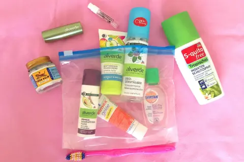 Reiseapotheke für den Flug: Tiger Balm, Duschgel, Insektenschutz und Zahnpflege.
