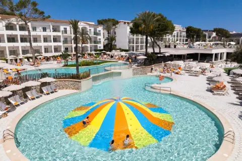 Bunte Wasserrutsche im Pool des Viva Cala Mesquida Resort & Spa. Kinder planschen im Wasser.