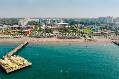 Traumhafter Blick auf das Limak Atlantis De Luxe Hotel & Resort mit Strand, Steg und türkisfarbenem Meer.