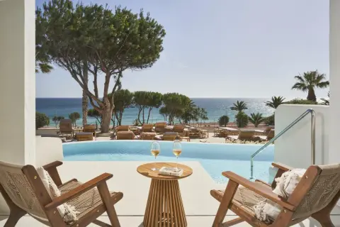 Entspannter Blick vom daia slow beach hotel conil auf den Pool und das Meer. Zwei Gläser Wein und ein Buch warten auf Sie.
