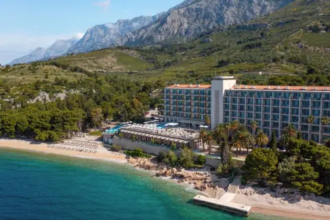 TUI Blue Jadran: Ein Hotel am Strand mit Pool und Bergen im Hintergrund, an der türkisfarbenen Adria.
