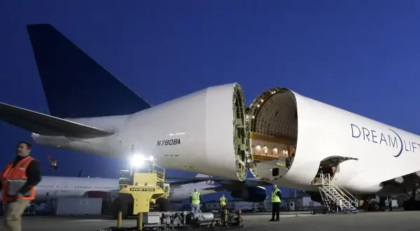 Ein Frachtflugzeug mit geöffneter Nase, bereit, Träume zu transportieren. Der Schriftzug "Dream Lifter" prangt auf dem Rumpf.