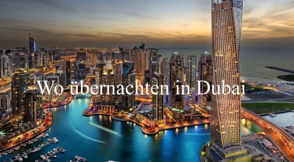 Glitzernde Skyline von Dubai bei Nacht, mit beleuchteten Wolkenkratzern und einem Yachthafen. Perfekt für einen Dubai Zwischenstopp.