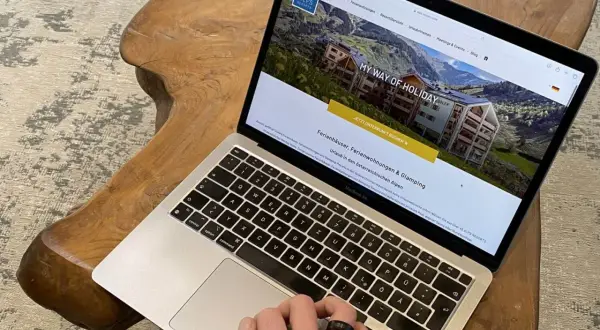 Laptop zeigt Webseite für Ferienhäuser in den Alpen. Perfekt für die einkaufsliste urlaub selbstversorger.