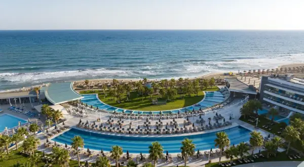 Traumhafter Blick auf das Lyttos Mare auf Kreta: Palmen, Pools und das azurblaue Meer.