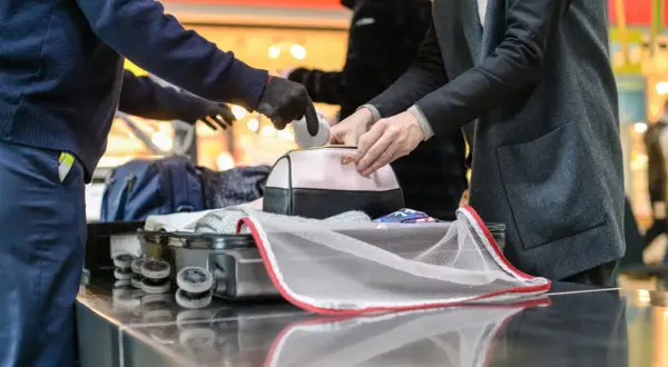Sicherheitskontrolle am Flughafen: Medikamente werden aus einer Kosmetiktasche genommen, bevor das Gepäck in den Flugzeug-Container kommt.