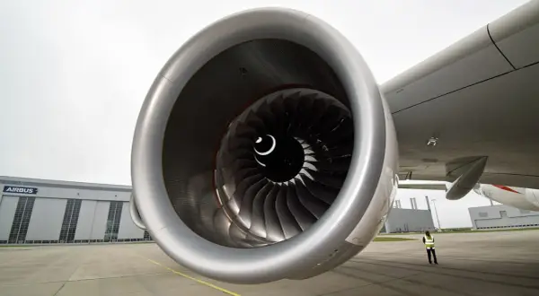 Detailaufnahme eines riesigen Triebwerks der A380. Im Hintergrund die Airbus-Halle und eine Person in Warnweste.