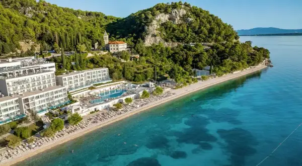 Traumhafter TUI Blue Adriatic Beach mit kristallklarem Wasser, weißen Hotels und grünen Hügeln. Ein Paradies zum Entspannen.