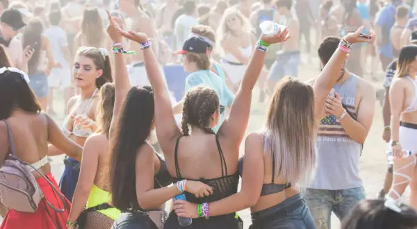 Festival-Besucher mit bunter Kleidung und Armbändern, die an eine Parookaville Packliste erinnern.
