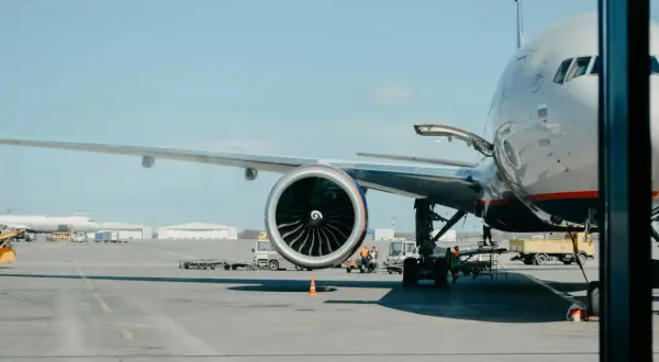 Großes Flugzeug mit geöffneter Ladeluke und Triebwerk auf dem Rollfeld. Bald geht es los, um mit dem Flugzeug fliegen zu können.